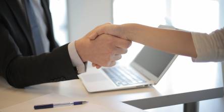 Female employee passing papers to her boss.