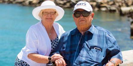 Senior couple sitting near beach shore