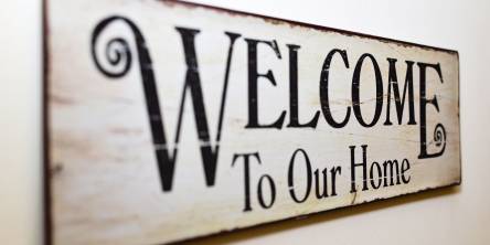 Wooden wall sign that reads 'welcome to our house'